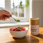 Dog sniffing a bowl of food with seaweed powder sprinkled on top, natural kitchen setting