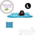 A small black and tan dog lies on a blue rectangular pet bed with a white paw print pattern. The image includes a circular 'L' size marker, a small inset of the bed's underside, and the Natural Dog Co.