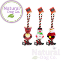 Three Christmas-themed dog toys by Natural Dog Co. shown on a white background: a reindeer, a snowman, and Santa Claus, each with a red-and-white striped rope handle and hanging tag.